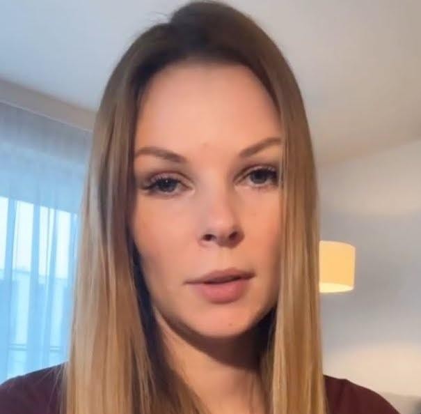 Małgorzata Tomaszewska podczas prowadzenia programu telewizyjnego, pełna energii i charyzmy na tle studia.