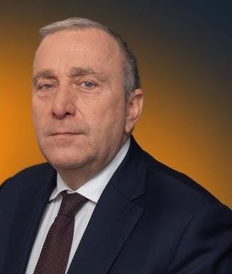 Grzegorz Schetyna w dynamicznej pozie w nowoczesnym biurze, symbolizującej jego aktywną rolę polityczną i strategiczne myślenie.