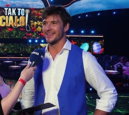 Mikołaj Roznerski z synem Antonim, uśmiechnięci, w czułym, naturalnym ujęciu.