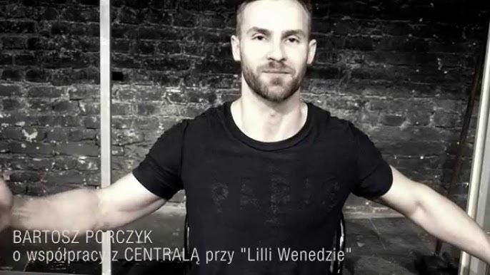 Bartosz Porczyk na scenie, odbierający nagrodę lub kłaniający się po występie, z uśmiechem i statuetką.