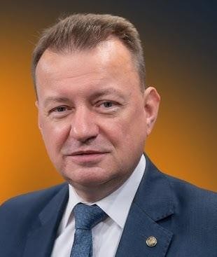 Mariusz Błaszczak w kontekście wojskowym, symbolizujący jego rolę jako ministra obrony narodowej.