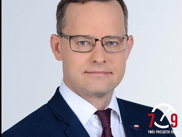 Marcin Romanowski podczas przemówienia w Sejmie, z dynamicznym tłem sugerującym debatę parlamentarną.