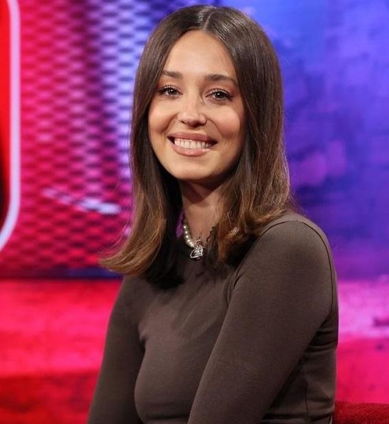 Izabella Krzan w studiu telewizyjnym, dynamicznie prowadząca program, z uśmiechem i profesjonalizmem.