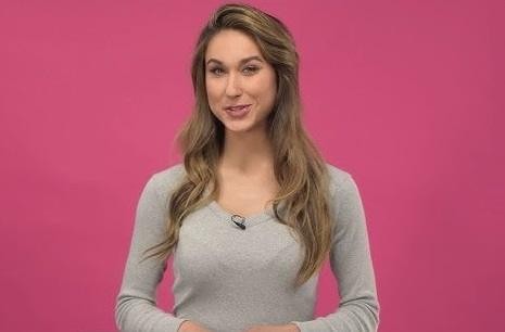 Ida Nowakowska uśmiechnięta w eleganckim stroju, z lekko rozmytym tłem studia telewizyjnego.