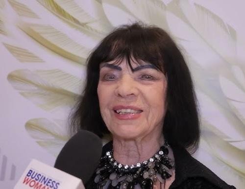 Sława Przybylska na scenie w latach 50. lub 60., śpiewająca z pasją do mikrofonu, oświetlona reflektorem, z elementami scenografii w tle, oddająca energię występu.